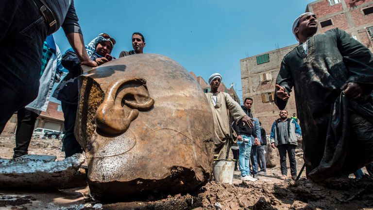 Workers at the site of a discovery of a statue, thought to be pharaoh Ramses II, in Cairo